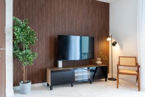 a living room with a television on a wooden wall at Vervana 2-Bedroom Apartment in Larnaca