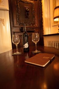 a bottle of wine and two glasses on a table at Au Petit Chateau les Bains in Morvan in Saint-Honoré-les-Bains