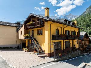 a yellow house with a staircase in front of it at A Casa di Nonna Ila in Courmayeur