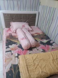 a bed with pink pillows and flowers on it at Kanaya house in Jakarta