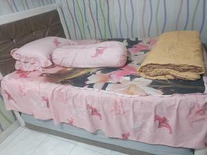 a unmade bed with pink flowers on it at Kanaya house in Jakarta