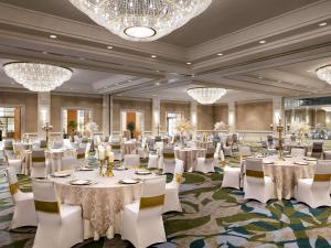 a banquet hall with white tables and chairs and chandeliers at Fairmont Waterfront in Vancouver +106 photos