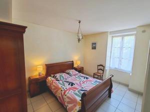 a bedroom with a bed and two tables and two lamps at La poterie in Castets