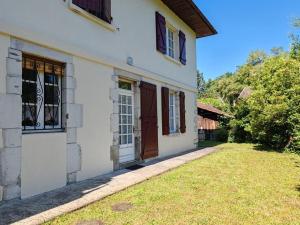 a white house with a door and a yard at La poterie in Castets