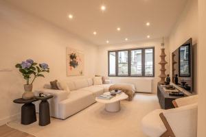 un salon avec un canapé blanc et une table dans l'établissement Luxury bright apartment in the city center - Amsterdam, à Haelen