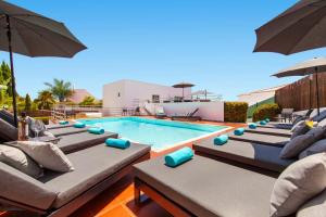 een zwembad met ligstoelen en parasols bij Villa Santa Rosa by Algarve Vacation in Armação de Pêra