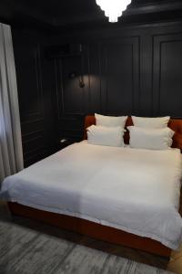 a bedroom with a bed with white sheets and pillows at Central Gate apartment in Chernivtsi