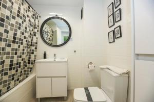 Un baño con un inodoro blanco y un espejo. en Alcazaba Del Mar parking next to the beach, en La Herradura