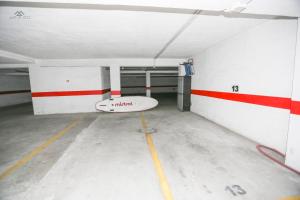 Un garaje vacío con una tabla de surf en el medio en Alcazaba Del Mar parking next to the beach, en La Herradura