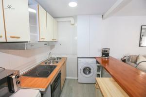 una cocina con fregadero y lavadora en Alcazaba Del Mar parking next to the beach, en La Herradura