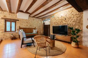 a living room with a tv and a table and chairs at El Molí Nou - Rural flats in Peñarroya de Tastavins
