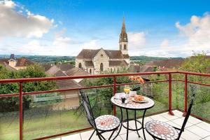 SermérieuT3 Les Tilleuls Sermerieu的一个带教堂的阳台的桌椅