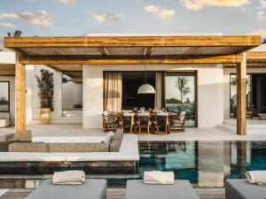 an outdoor dining area with a table and a pool at Serendi Villas in San Antonio