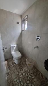 a bathroom with a toilet and a window at hotel beachfront in Calangute