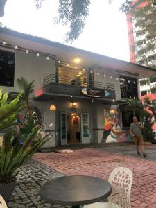 a man standing in front of a building with a table at Northern Cove Penang in Tanjung Bungah
