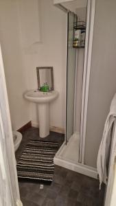 a bathroom with a sink and a shower with a mirror at Seaview, Lower Flat in Leven-Fife +2 photos