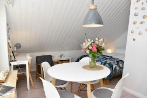 a room with a table and chairs and a bedroom at Herzmuschel in Hörnum