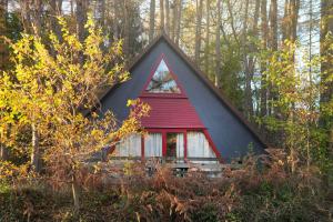 una pequeña casa roja y negra en el bosque en Domaine Long Pre, en Stavelot