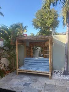 a wooden pergola with a blue covering on a patio at Villa Fleur de Tiaré in Saint-Paul