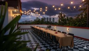 a long table with chairs and lights on a patio at MiraNamin Nest LANTANA SUITE in Unique Historic Home with Garden Access, Rooftop, Bathtub, Private Kitchen in Manila +33 photos