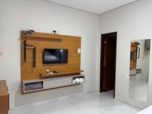 a living room with a tv on a wall at Pousada Museu de Piatã in Piatã