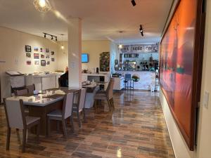 a restaurant with tables and chairs and a kitchen at Pousada Museu de Piatã in Piatã