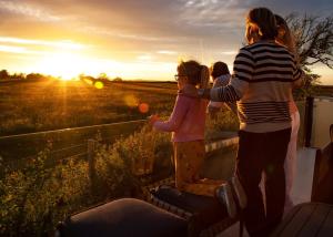 a group of people standing in a field at sunset at Heathergate Boutique Holiday Park in Hexham +128 photos