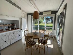 Una cocina y un comedor con mesa y sillas. en Chacra La Margarita by Posada de la Flor, en Colonia del Sacramento