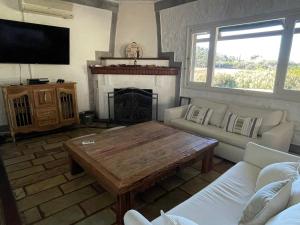 sala de estar con mesa de centro y chimenea en Chacra La Margarita by Posada de la Flor, en Colonia del Sacramento