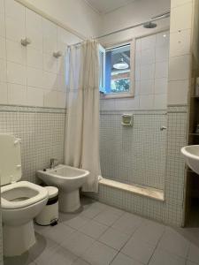 Un baño con inodoro, ducha y lavabo. en Chacra La Margarita by Posada de la Flor, en Colonia del Sacramento