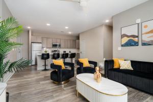 a living room with black furniture and a kitchen at Cozy Lux Haven Whitestown in Whitestown