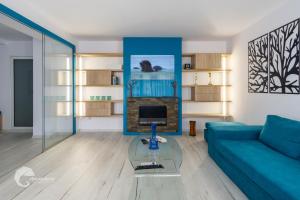 a living room with a blue couch and a glass table at Apartament luxos în Onești in Onești