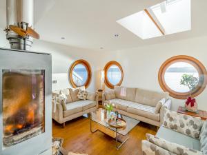 a living room with two couches and a fireplace at Shore House in Kilcreggan