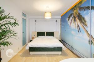 a bedroom with a bed and a palm tree mural at Apartament luxos în Onești in Onești