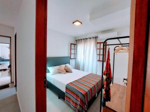 1 dormitorio pequeño con 1 cama y 1 litera en Cedro - Flat recém inaugurado, 50mts da Praia, Churr, Piscina, WiFi eficiente, Netflix, en Paraty 8 fotos más