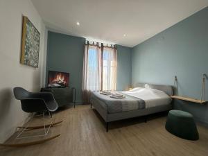 a bedroom with a bed and a chair and a television at C Oslo - Appartement spacieux proche centre-ville in Charleville-Mézières