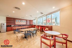 a restaurant with tables and chairs and a kitchen at Scala Hostel in Bangkok