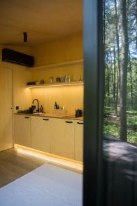 a kitchen with white cabinets and a large window at Bento Houses in Kąck