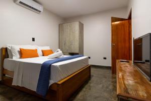 une chambre avec un grand lit avec des oreillers orange dans l'établissement Nana Suites, à Foz do Iguaçu 20 autres photos