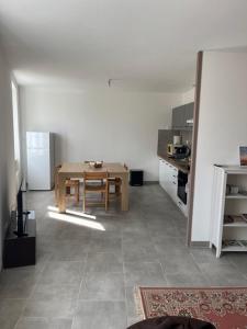 a living room with a table and a kitchen at Appartement meublé tout équipé - Mesnard-La-Barotière in Mesnard-la-Barotière