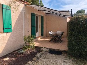 un patio con tavolo e sedie accanto a un edificio di Gite les Mazets du Rouret a Saint-Christol-lès-Alès