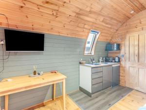 a kitchen with a table and a tv on the wall at Boxing Hare - Uk39915 in Heckington