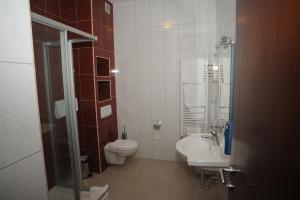 a bathroom with a toilet and a sink at Hotel Balkana Vidović in Mrkonjić Grad