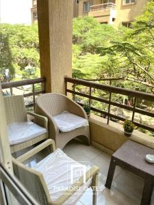 a balcony with two chairs and a table on a balcony at Paradise Gates Madinaty in Madinaty
