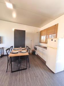 a kitchen with a table and chairs and a refrigerator at Apartamentos La Playa in Piriápolis +71 photos