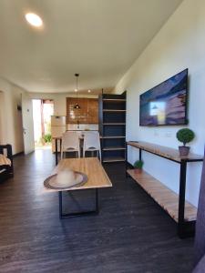 a living room with a table and a kitchen at Apartamentos La Playa in Piriápolis