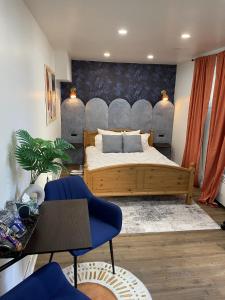 a bedroom with a bed with a blue wall at Chambre de répit au bord de l'eau in Chambly