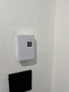 a white outlet on a wall with a tv at Chambre de répit au bord de l'eau in Chambly +27 photos