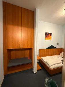 a bedroom with a bed and a wooden cabinet at SVG Hotel Diversi in Ludwigshafen am Rhein