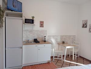 a small kitchen with a table and a white refrigerator at Alloggio San Francesco in Peschiera del Garda +29 photos